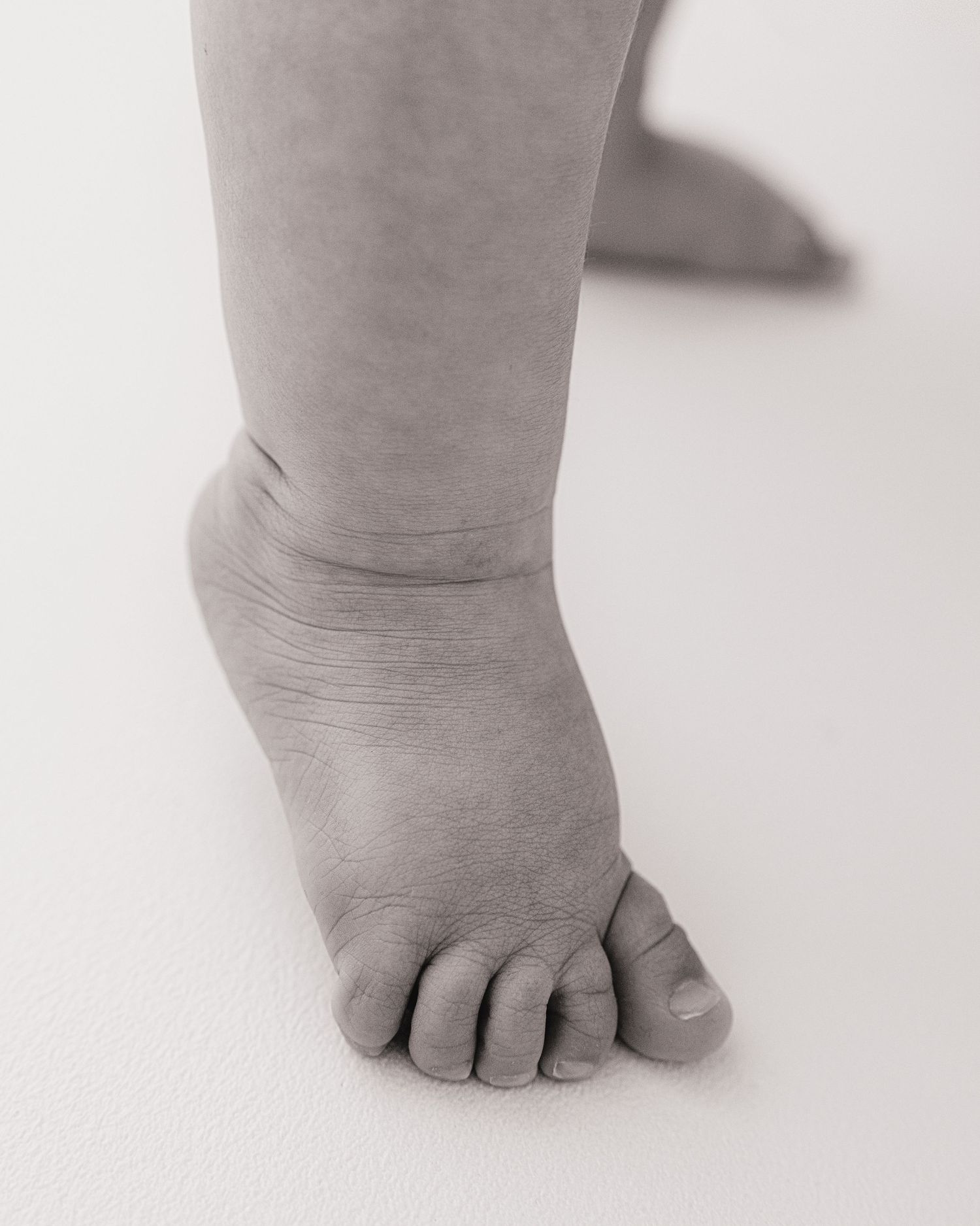 delicate baby toes captured during milestone session in Faye McRae's all-white South Ayrshire photography studio