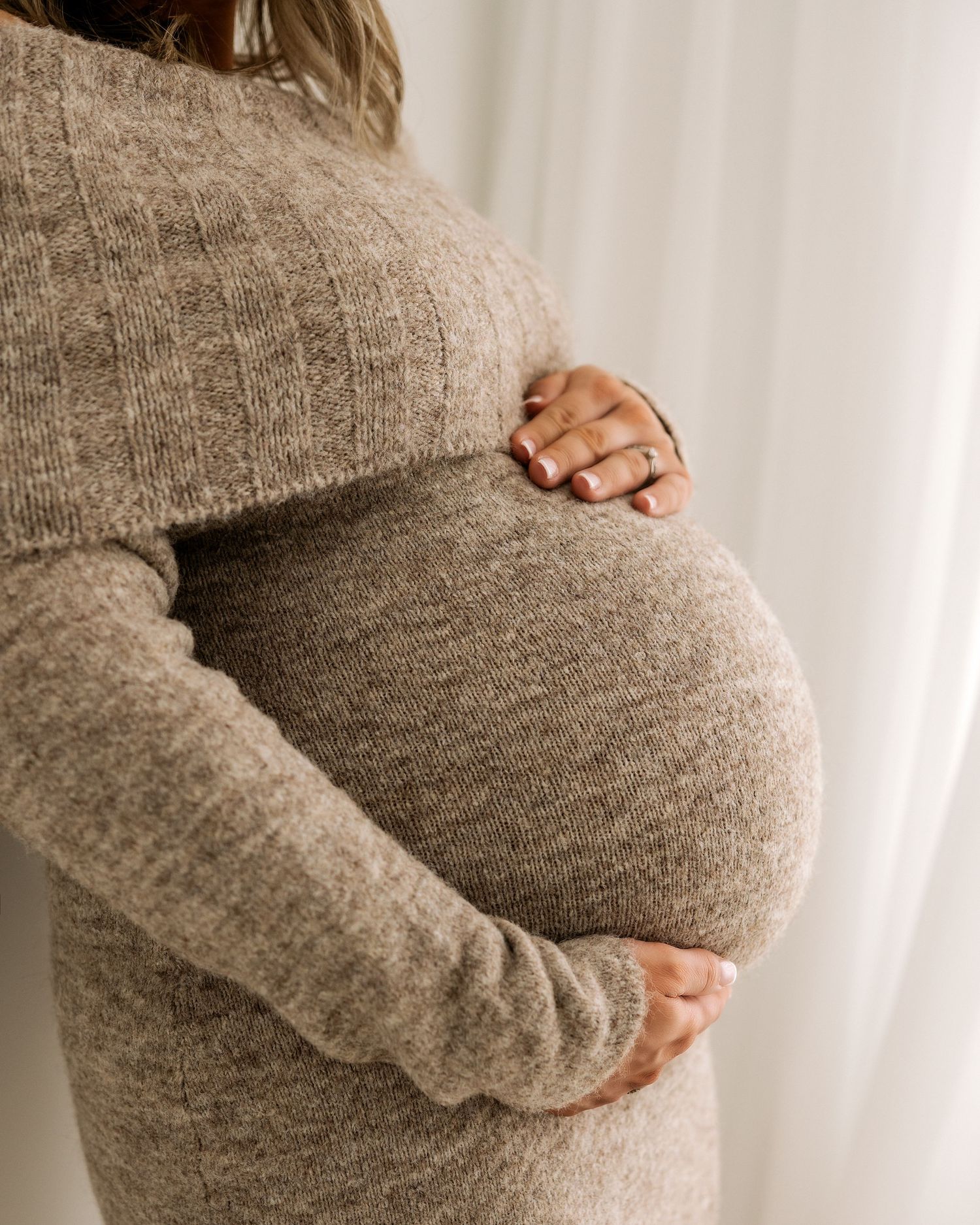 the focus is completely on mums beautiful bump she is cradling with her hands during her natural maternity session in Ayrshire