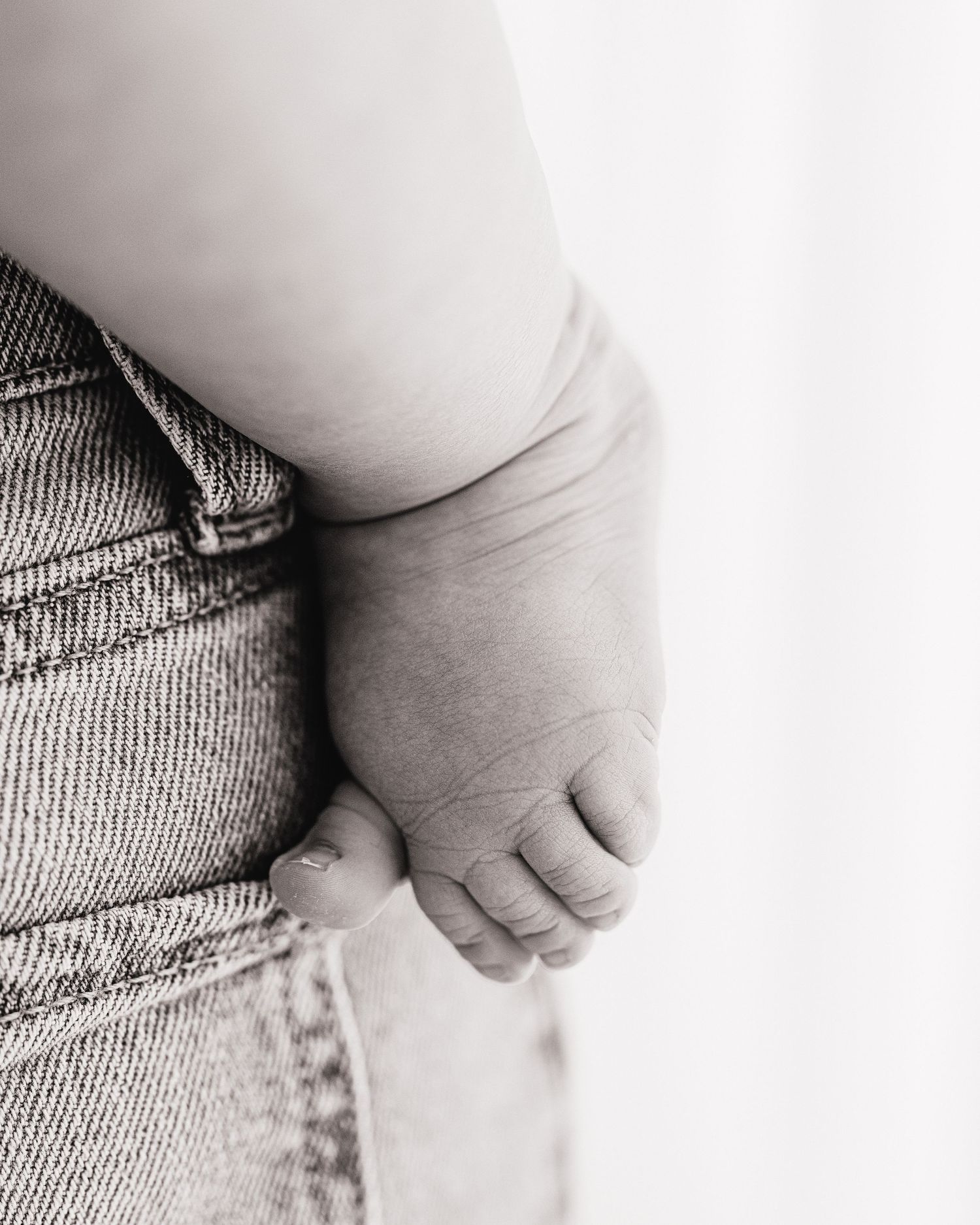 6 month old baby foot, her toe against the pocket of her mums jeans, simple & authentic captured in Ayrshire studio during milestone session
