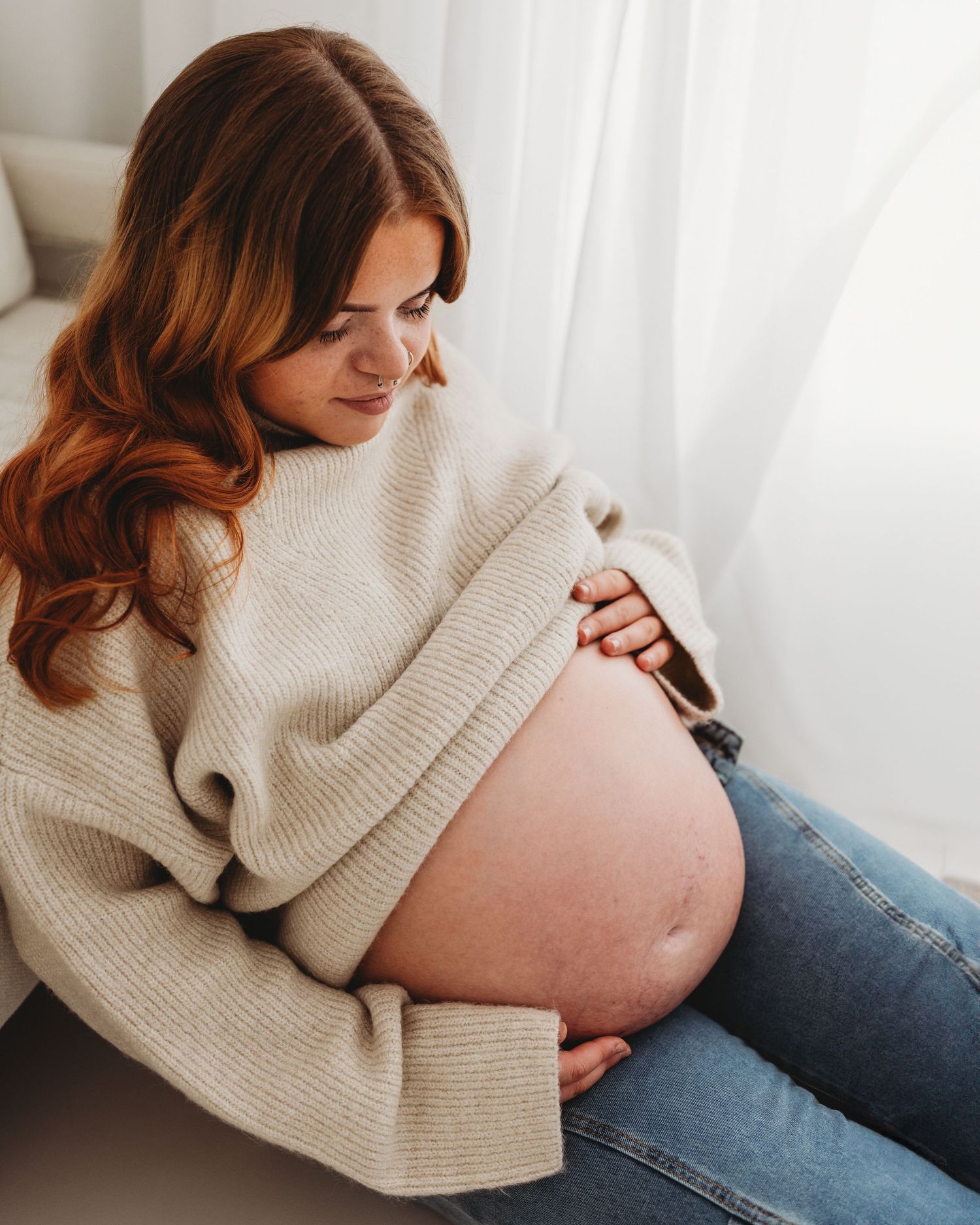 first time mum cradles her bump in Ayrshire studio during her relaxed modern maternity session