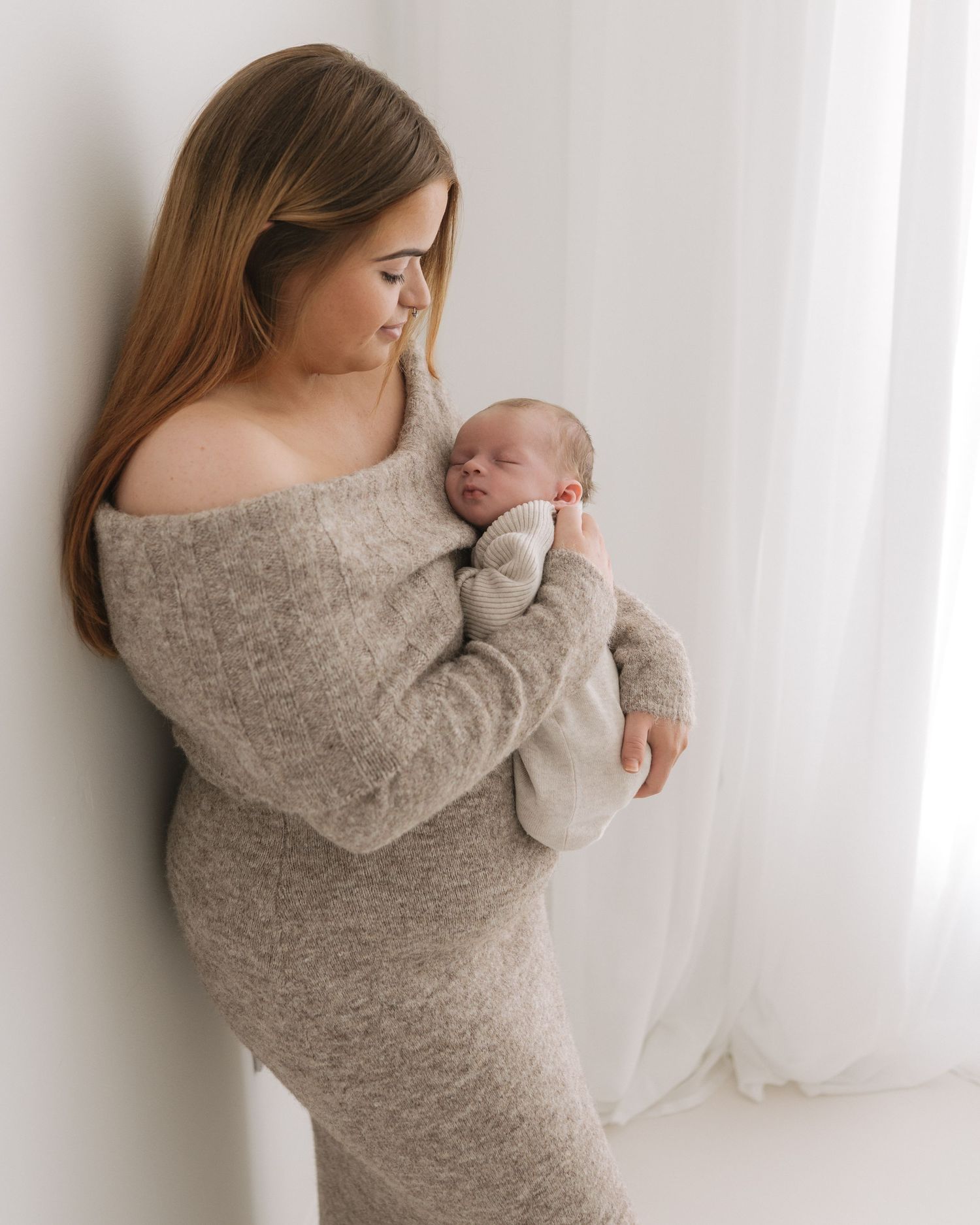 Ayrshire first time mother proudly looks down at her beautiful newborn baby who is snuggled into her chest