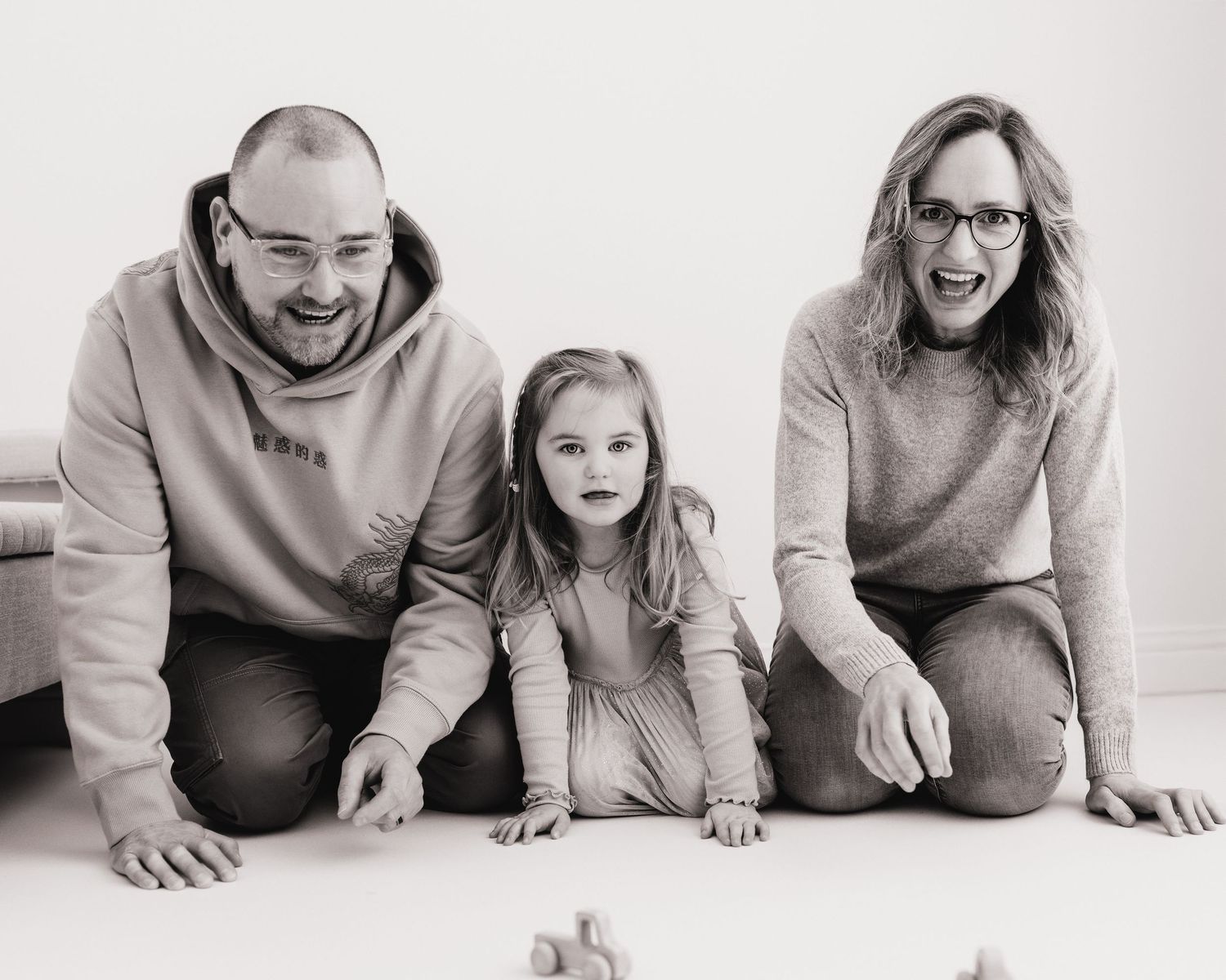 this family race cars across the studio floor, playing together to create beautiful natural memories during their family session in Ayrshire