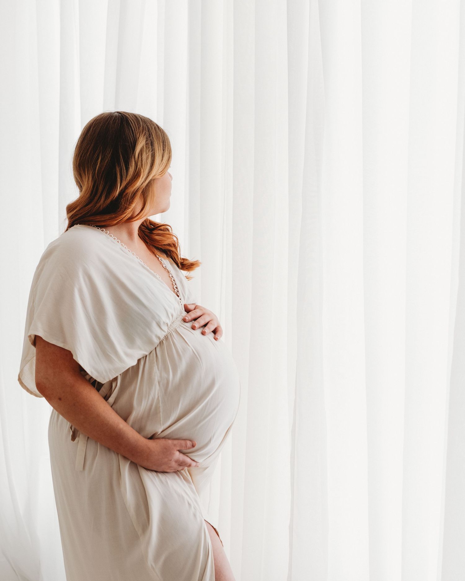 Modern studio maternity portrait of expectant mother in soft neutral gown, captured by Ayrshire newborn, maternity and family photographer