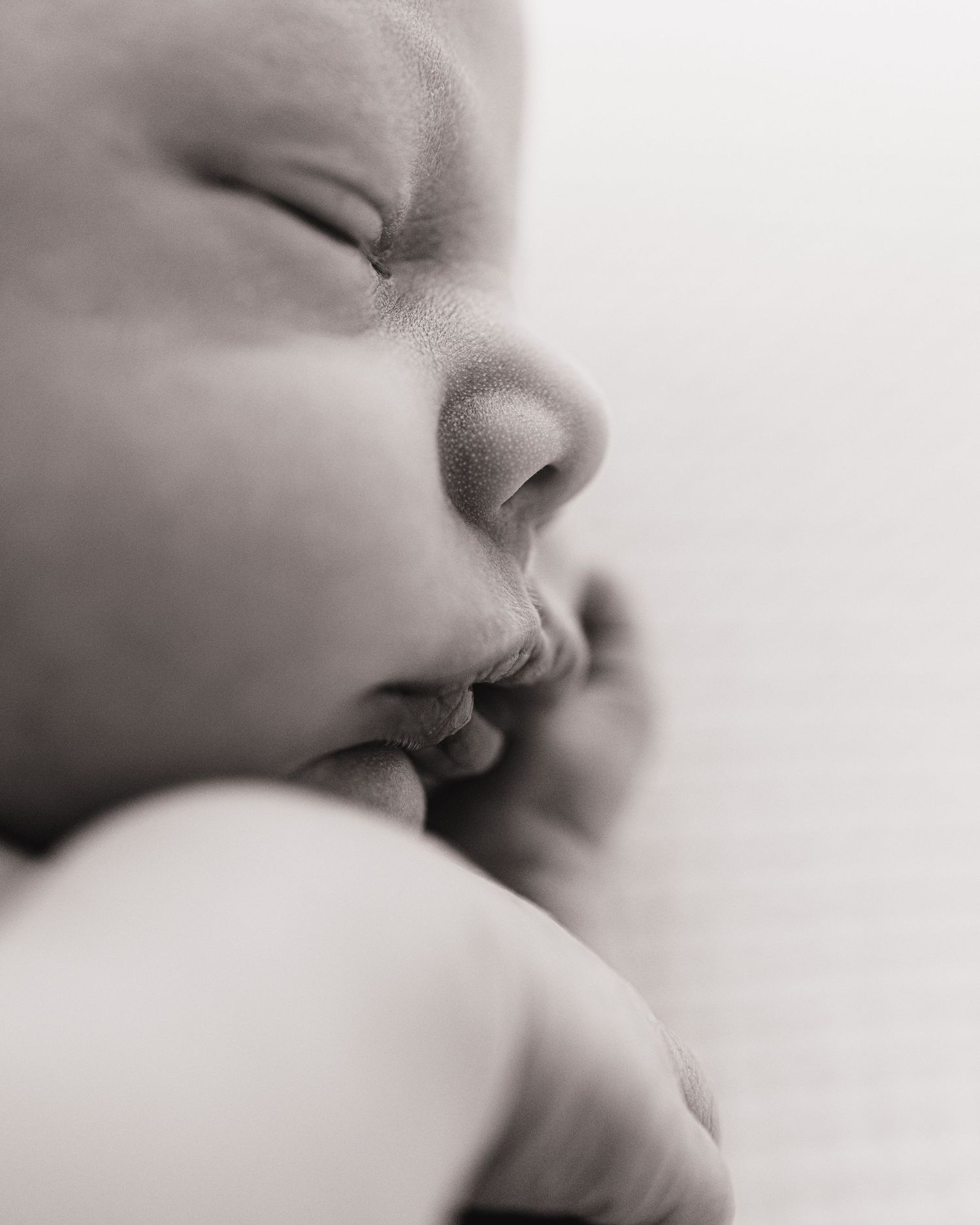 newborn baby boy sleeps soundly on his side during his minimalist natural newborn session in Faye McRae's photography studio in Ayrshire