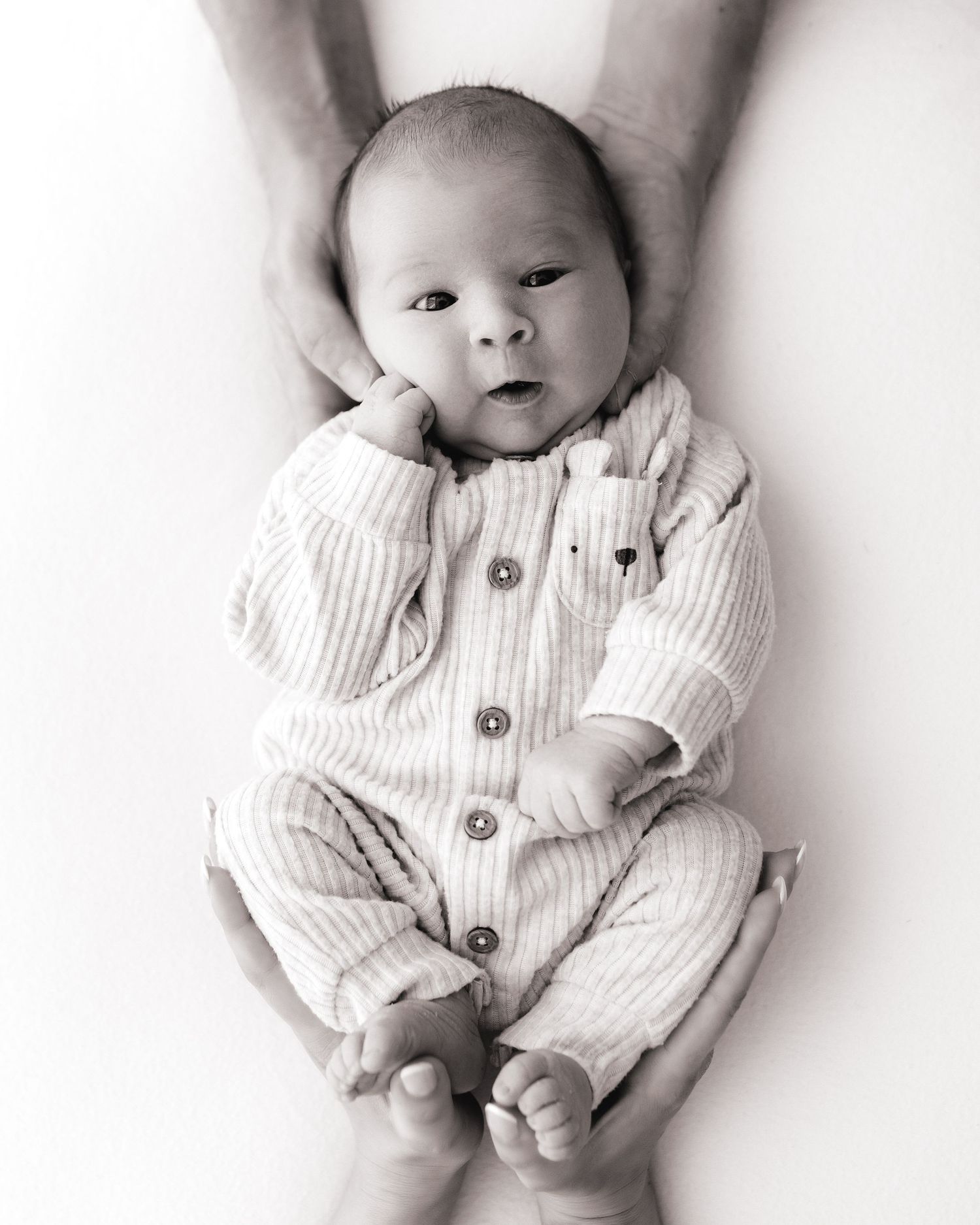 newborn baby is awake and alert, looking directly into the camera during her relaxed baby-led newborn session in South Ayrshire studio