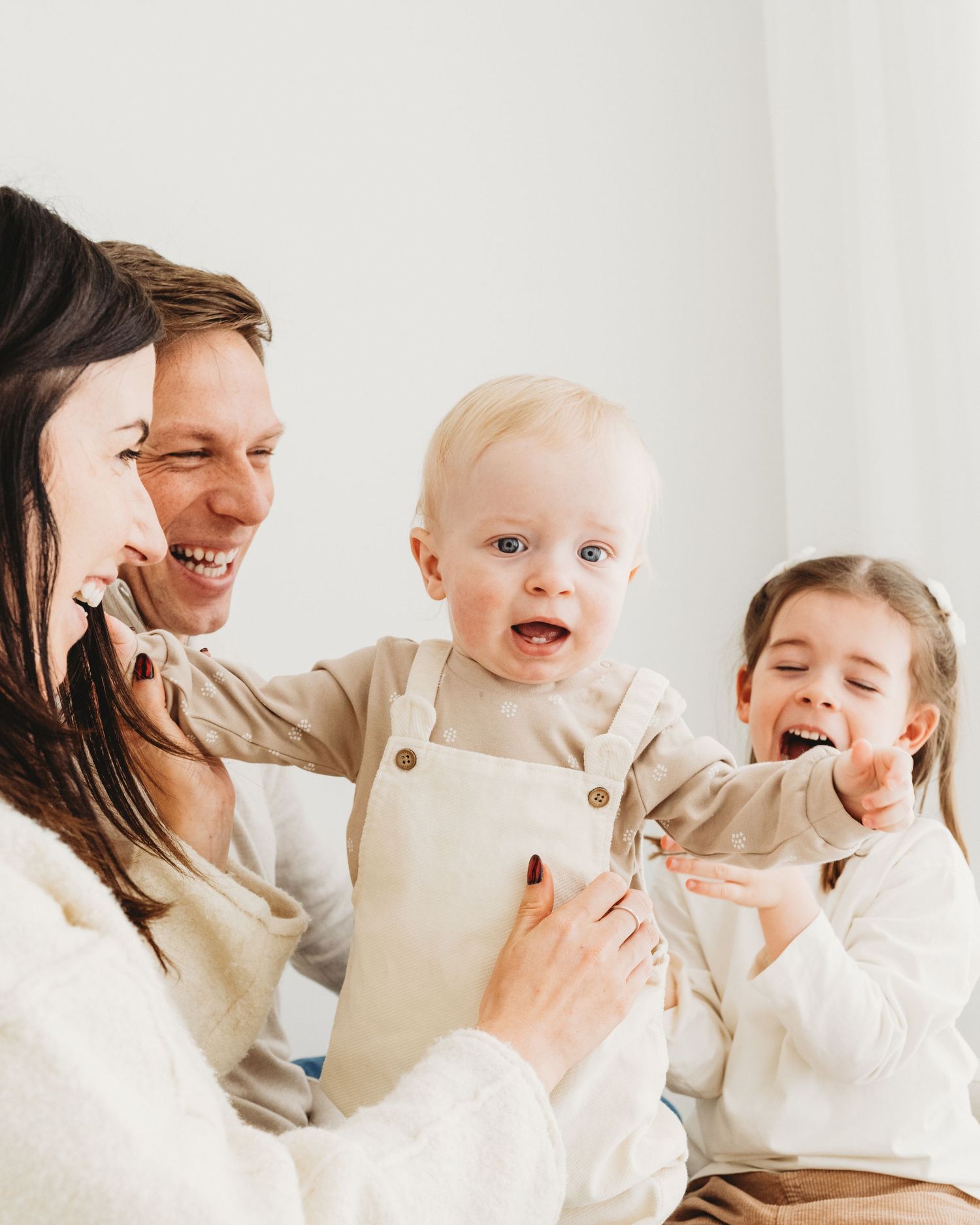 the chaos of family life is summed up in this picture of laughter and mayhem during a family photoshoot