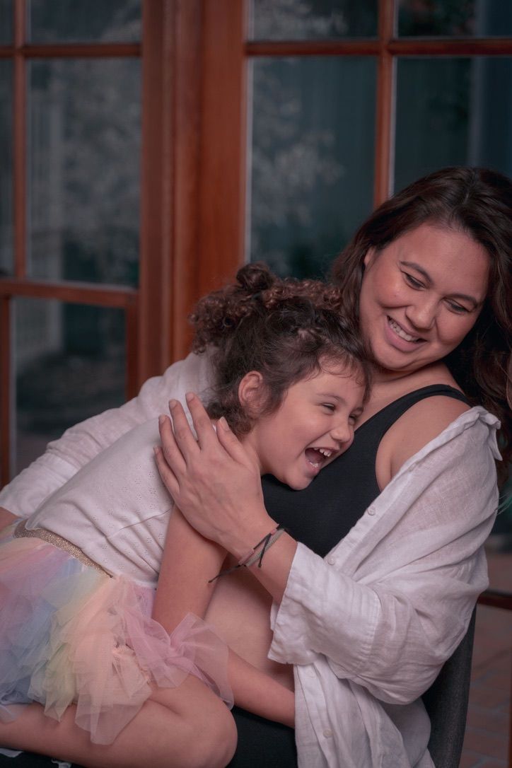 A joyful candid moment between parent and child sharing laughter and embrace.