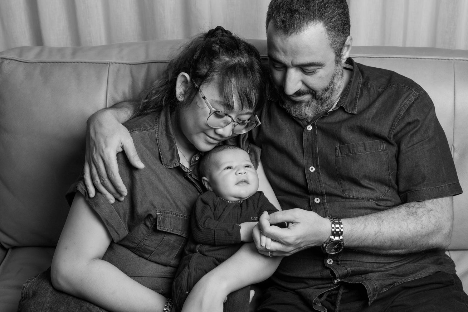 Series of candid black and white family moments on a light-colored couch.