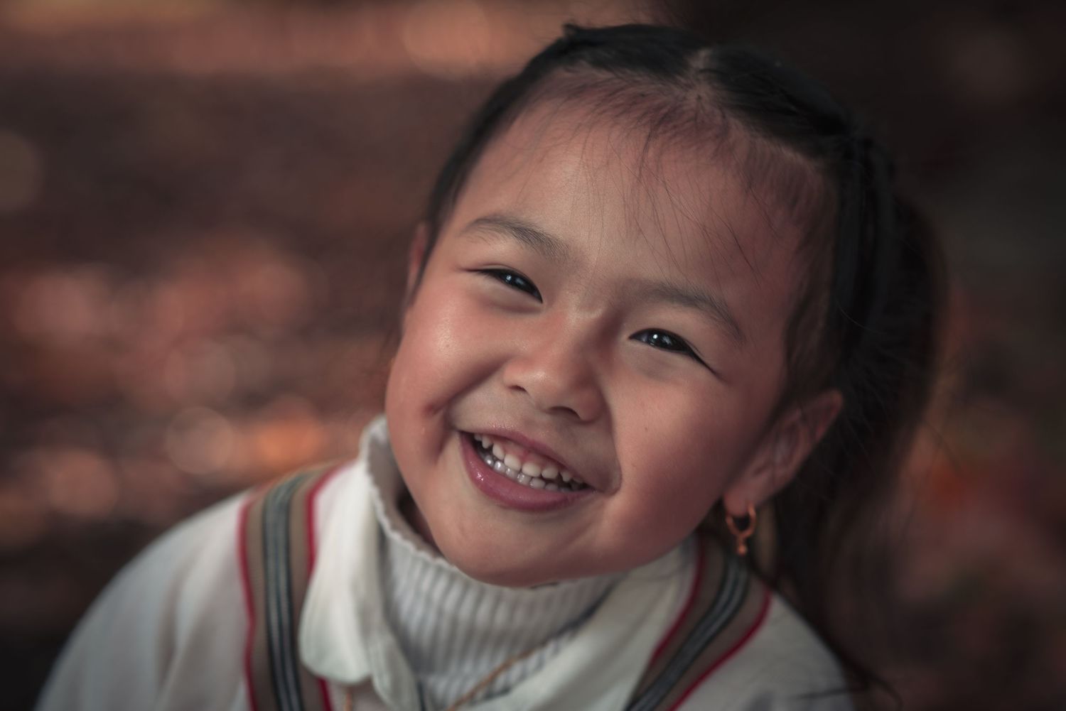 A joyful expression captured in warm autumn lighting.