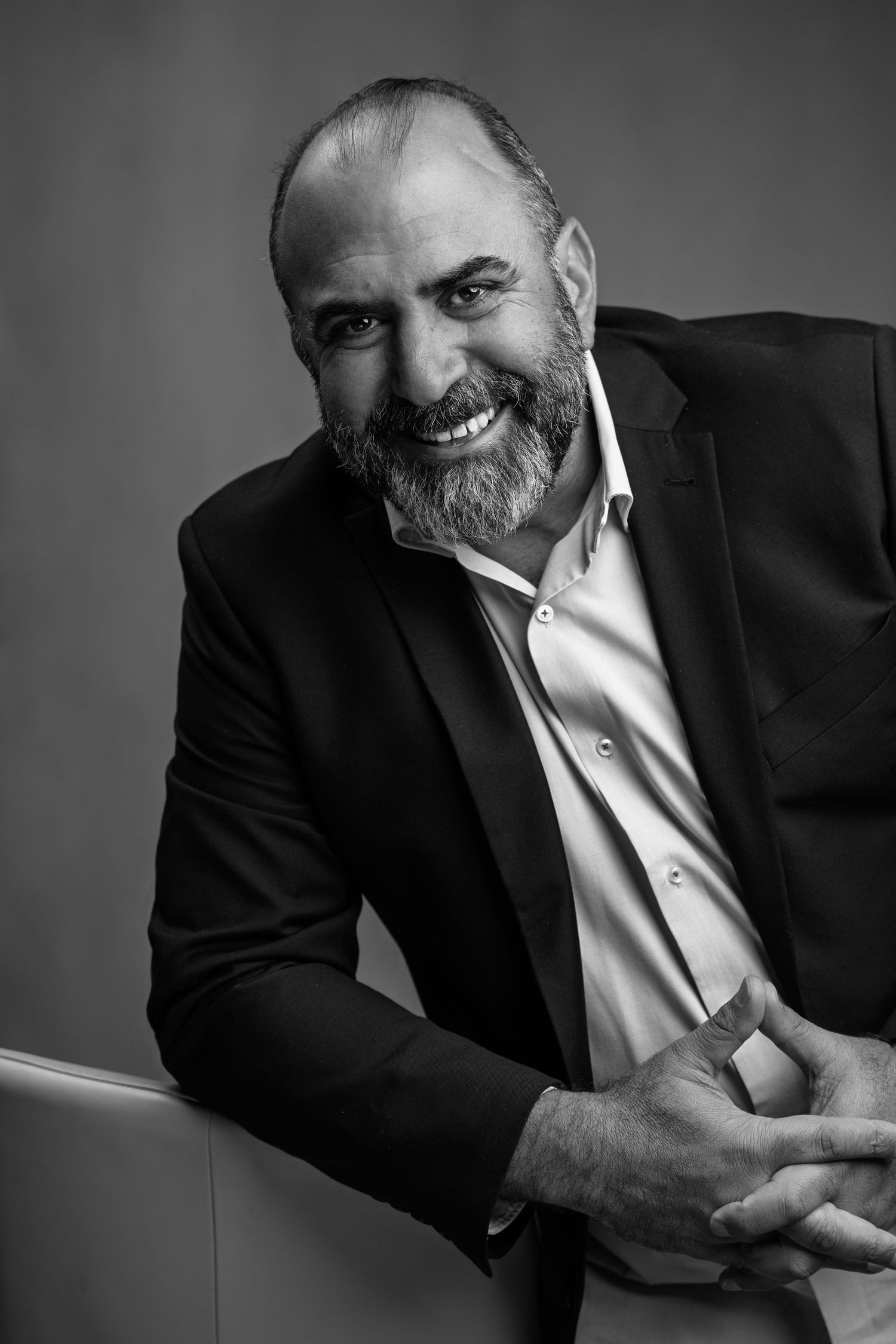 Black and white portraits of a man in suit showing various casual poses and expressions.