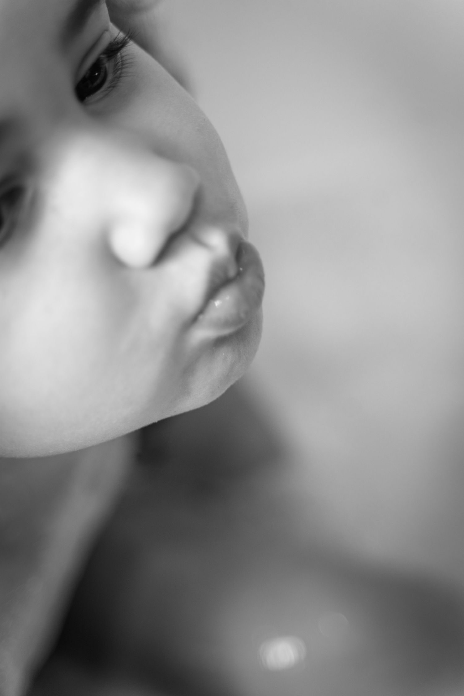 An artistic black and white close-up portrait showing partial face features.