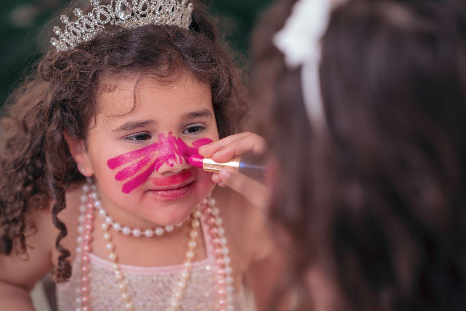 A playful sequence of photos shows someone wearing a pearl necklace and pink ribbon across their nose in different poses.