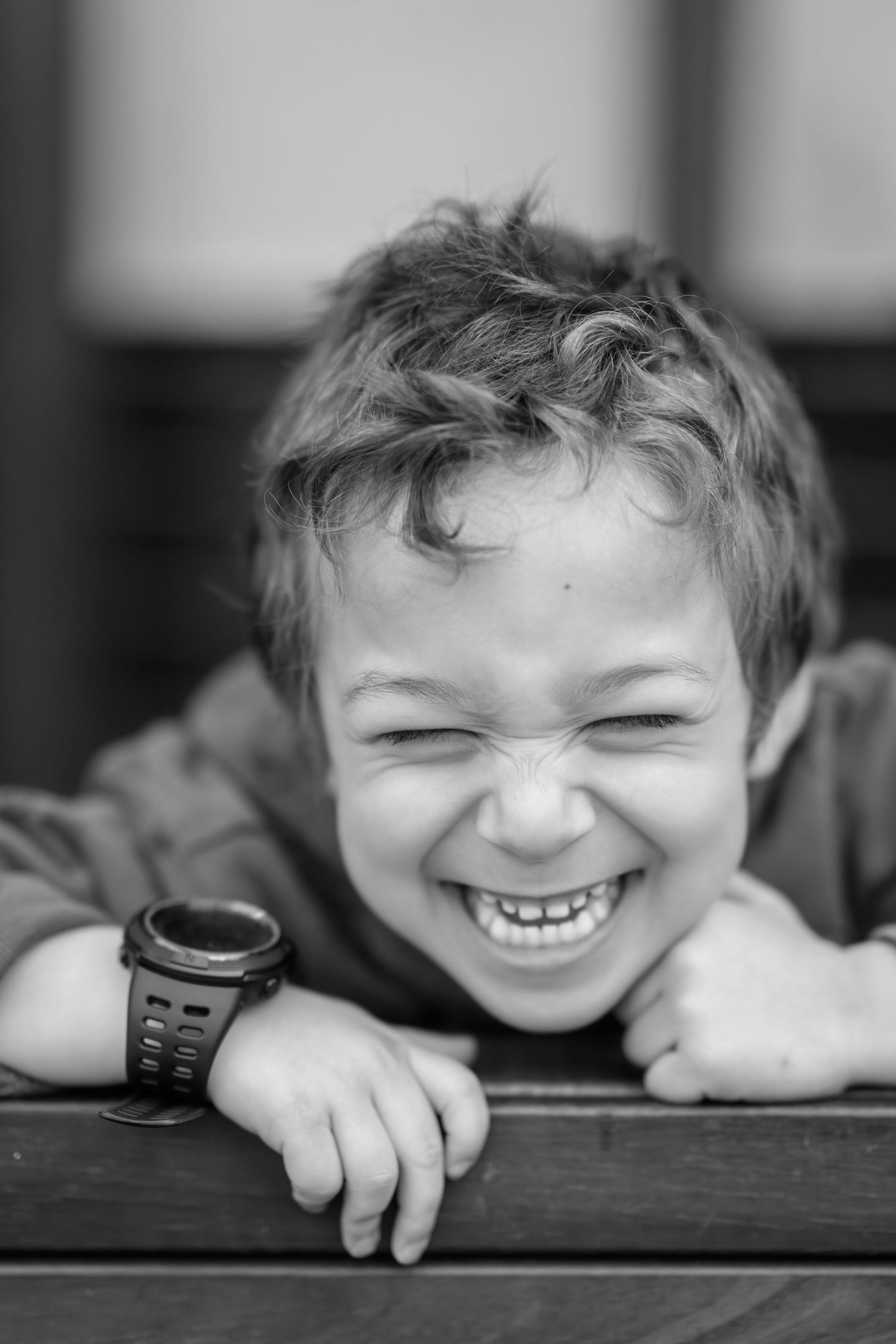 Black and white portrait showing joyful expressions through wooden railings.