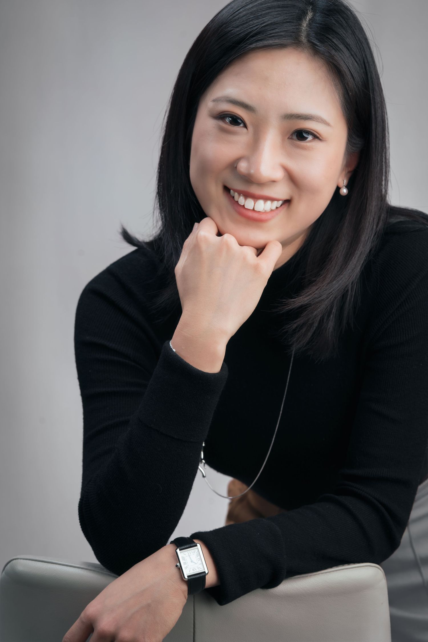 Series of casual portrait shots featuring a smiling person in black sweater against light gray backdrop.