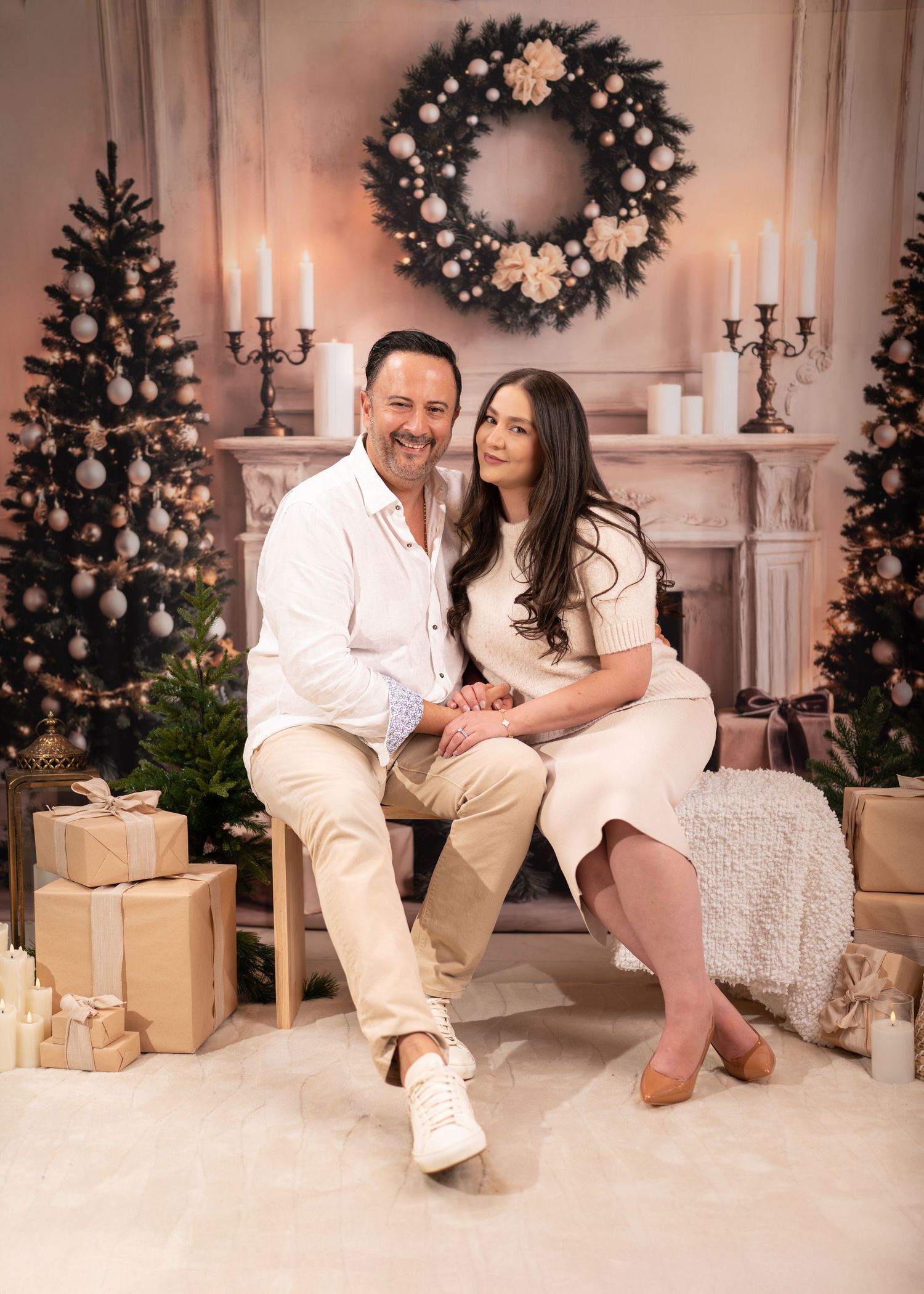 Three connected photos showing a family in white clothing posing by a decorated Christmas fireplace and tree.