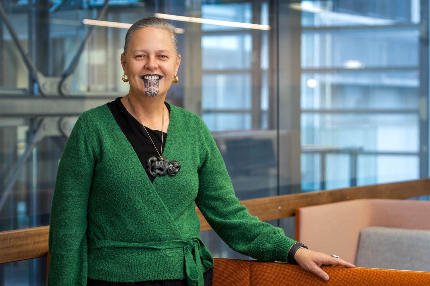 Corporate portrait in office setting featuring a person wearing a green sweater.