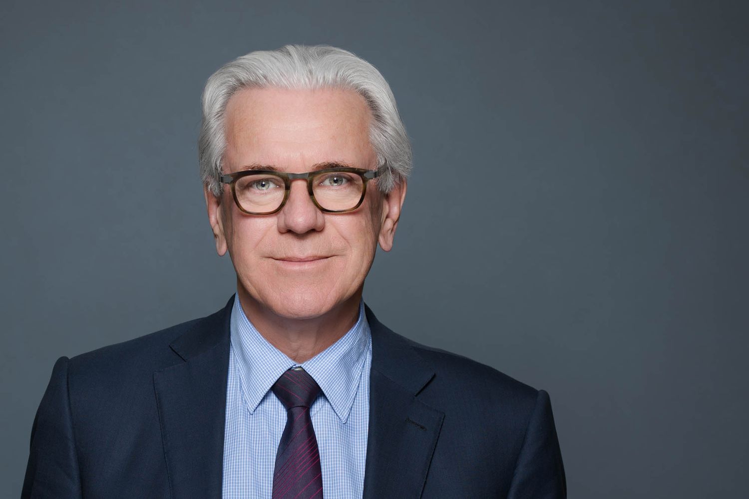 Professional headshot of Dr John Wyeth against a dark gray background.