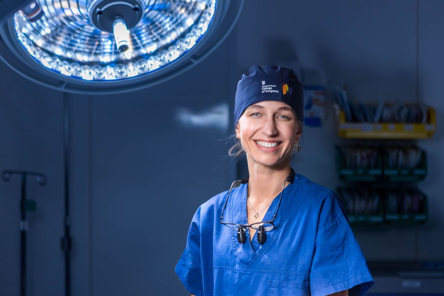 Medical operating room with bright blue surgical lights illuminating the ceiling.