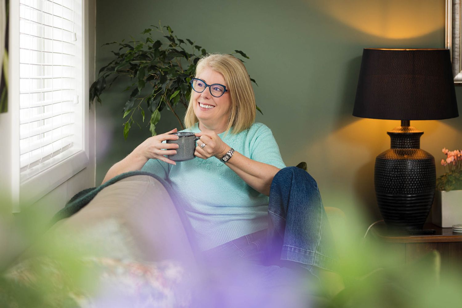Homes with Soul owner with houseplants, warm lighting, and sage green walls.