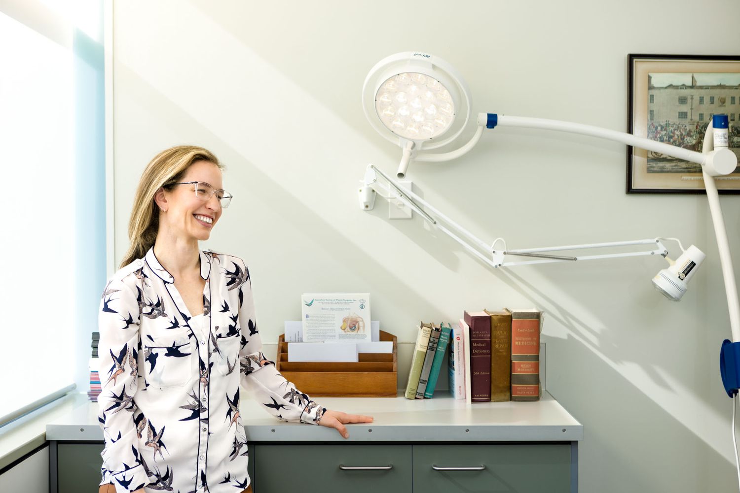 Healthcare professional in white coat smiling and working in medical office with equipment.