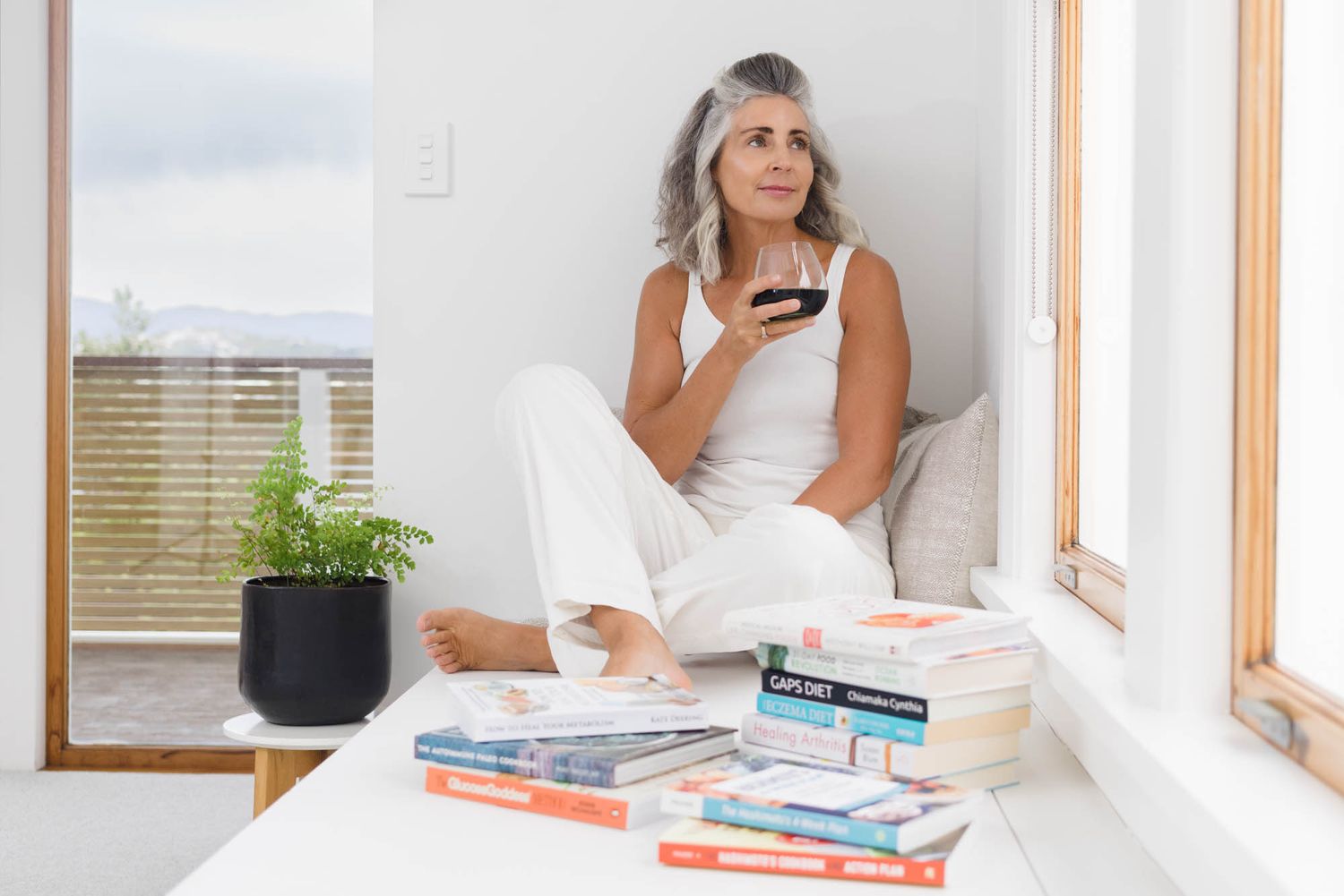 Relaxed reading session in bright minimalist room with white shelving units.