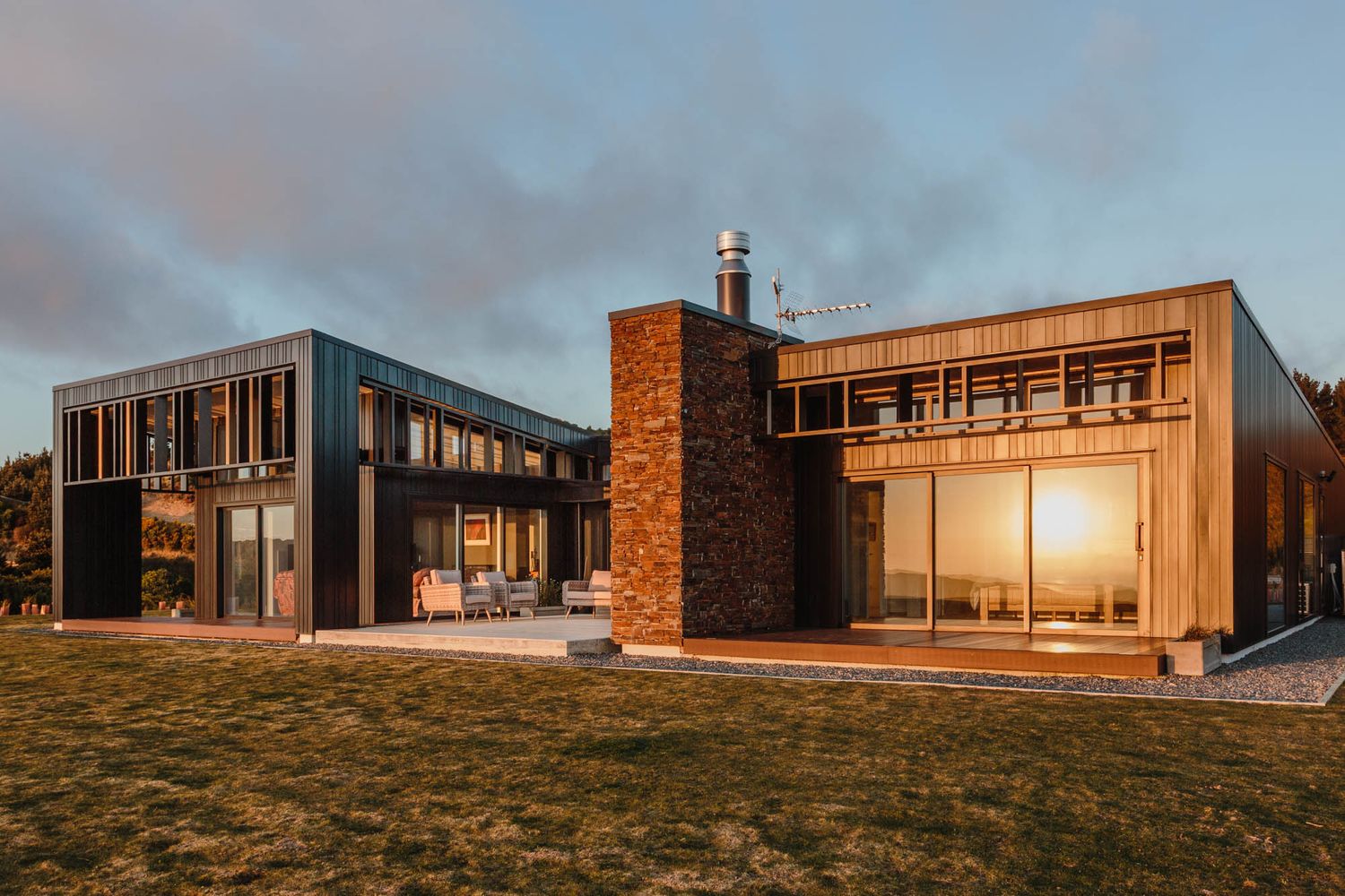 Panoramic view of modern architectural buildings at sunset with golden light on hillside.