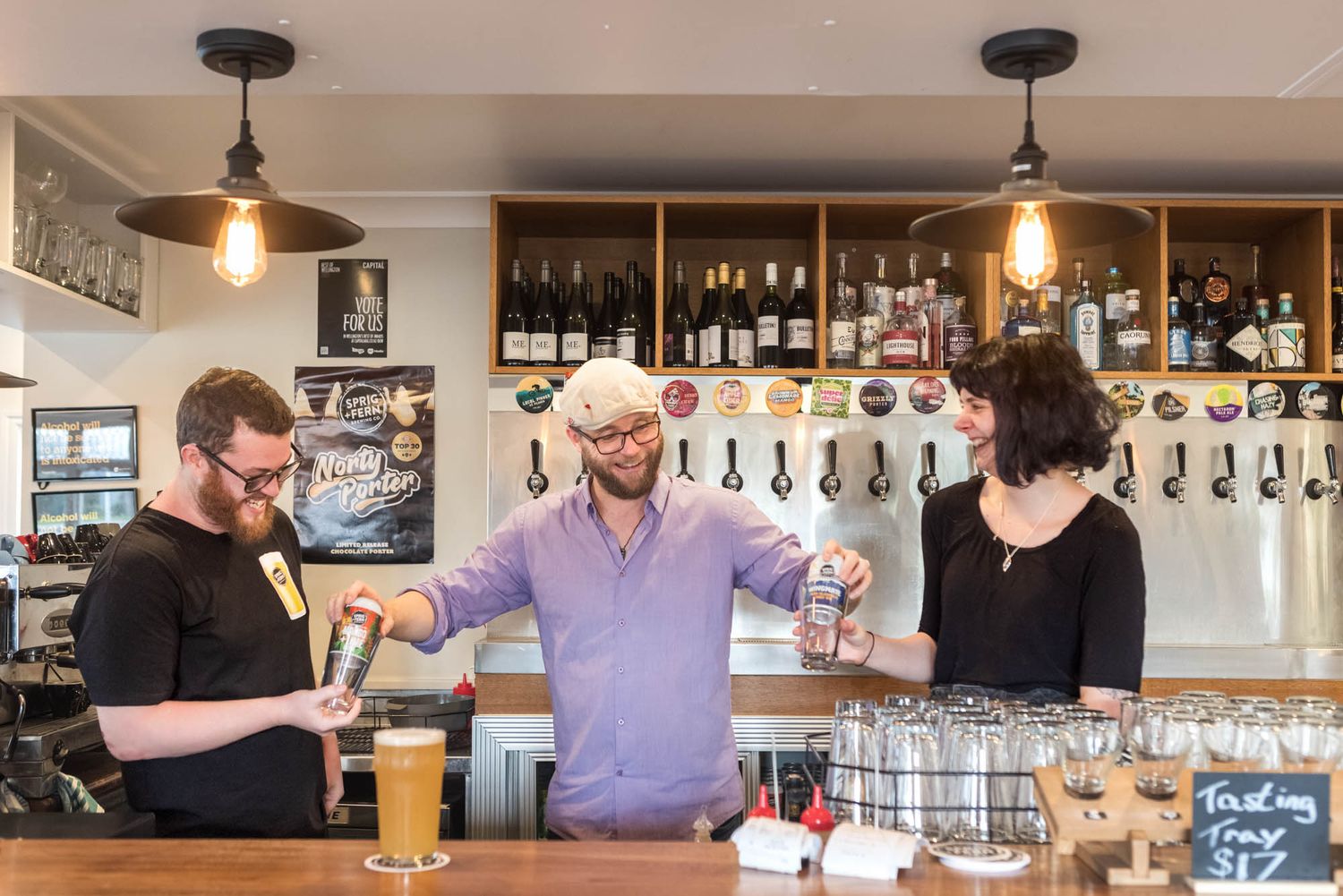 Sprig and Fern Tavern interior featuring wooden counter, pendant lights, and multiple beer taps.
