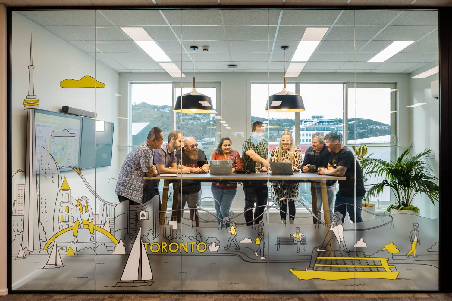 Modern office space at Arlo with collaborative meeting areas and yellow design elements throughout the workspace.