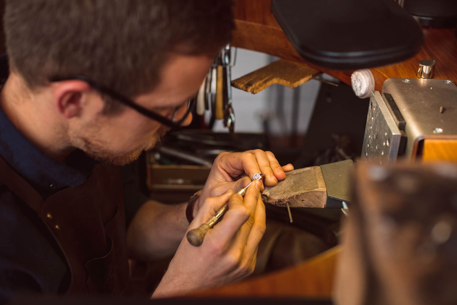 Craftsperson working on jewellery in a workshop setting.