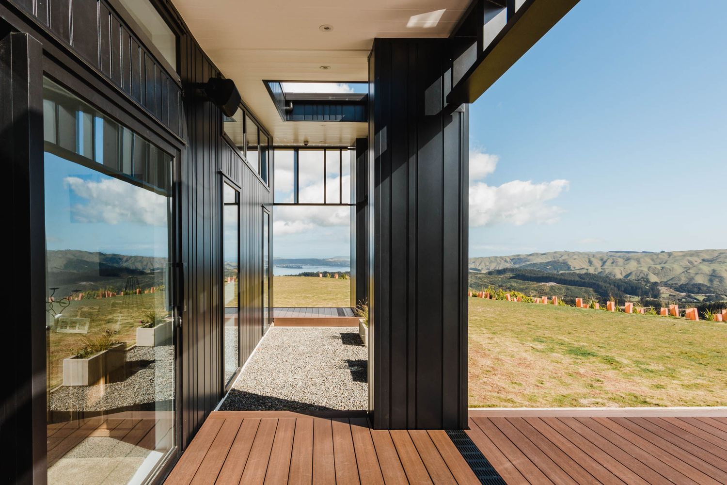 Wooden deck terrace extending from modern house with panoramic views.