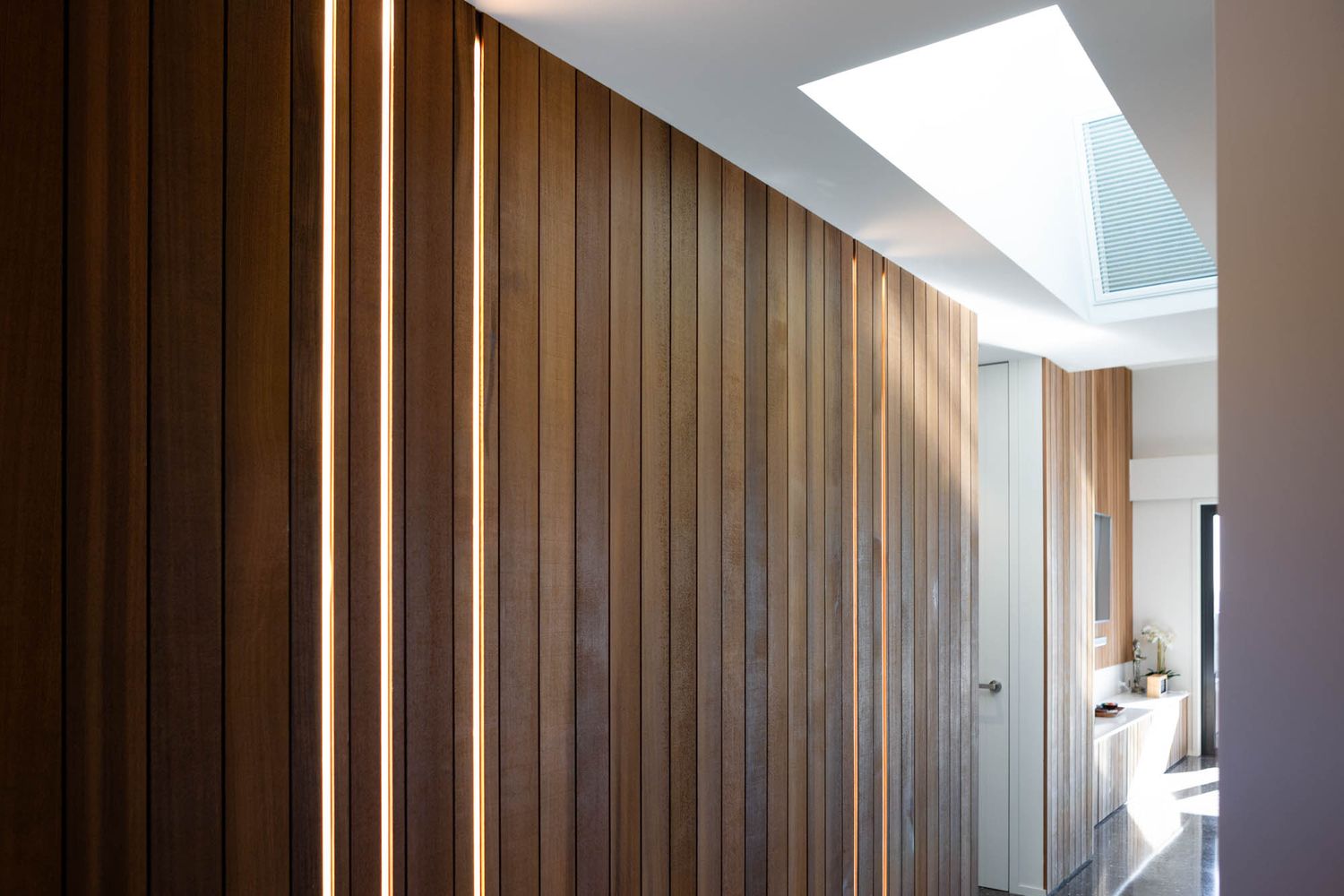 Interior hallway with dramatic wood paneling and integrated LED lighting strips.