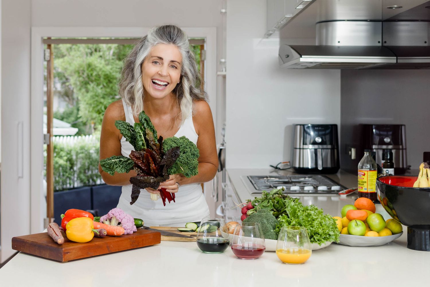 Jo Williment of Sage Studio preparing nutritional products at her kitchen counter.
