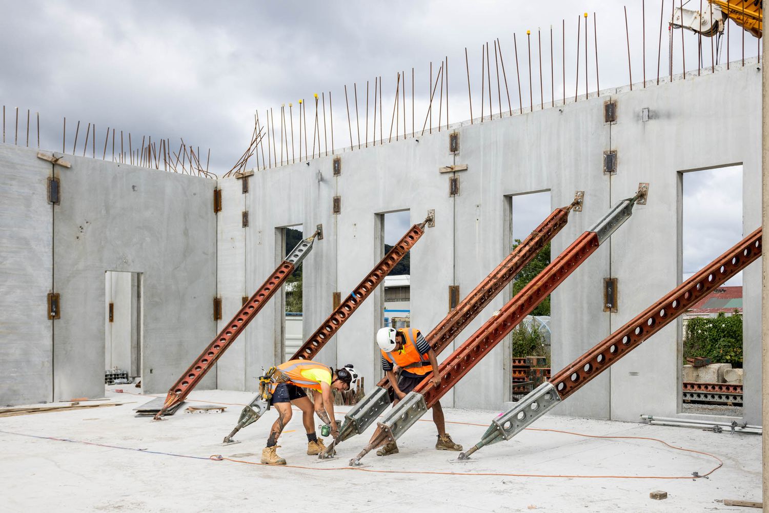 Concrete wall panels with exposed rebar being installed at a Maycroft construction project.