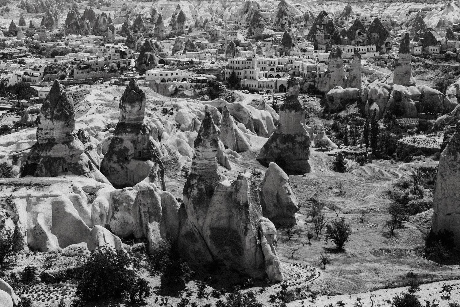 Hilltop view of Cappadocia landscape with carved structures and formations.