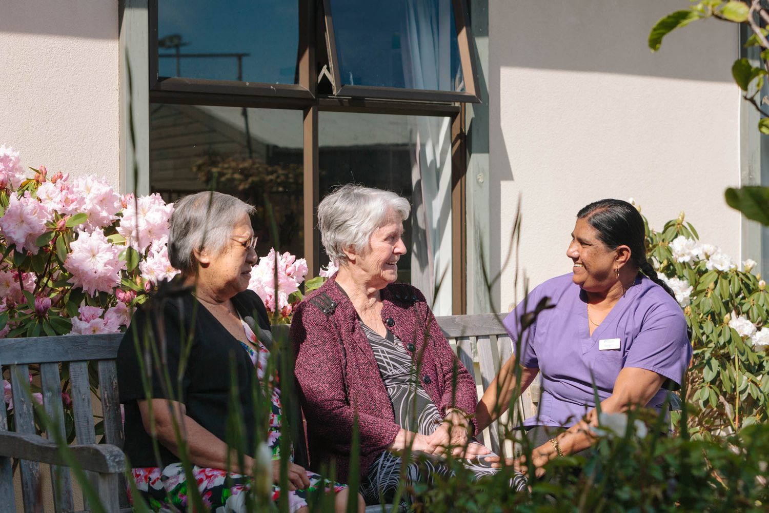 Outdoor patio area with plants where people are gathered for social activities.