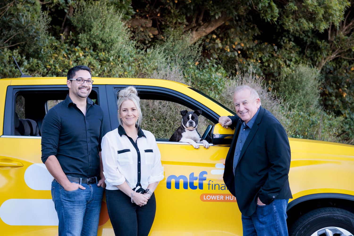Group of MTF Lower Hutt staff posing next to their company vehicle outdoors.