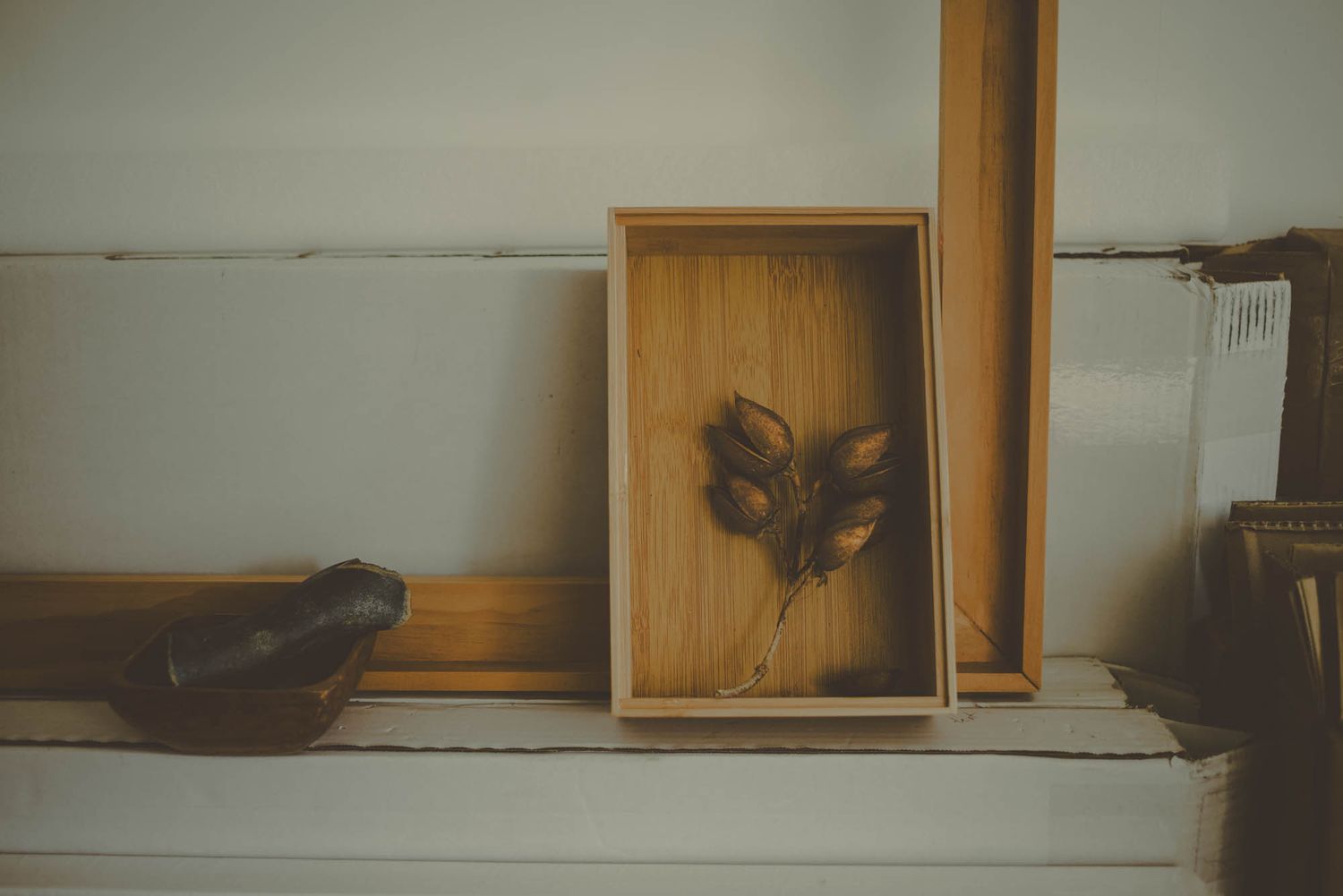Decorative wooden box with butterfly artwork displayed on a white shelf.
