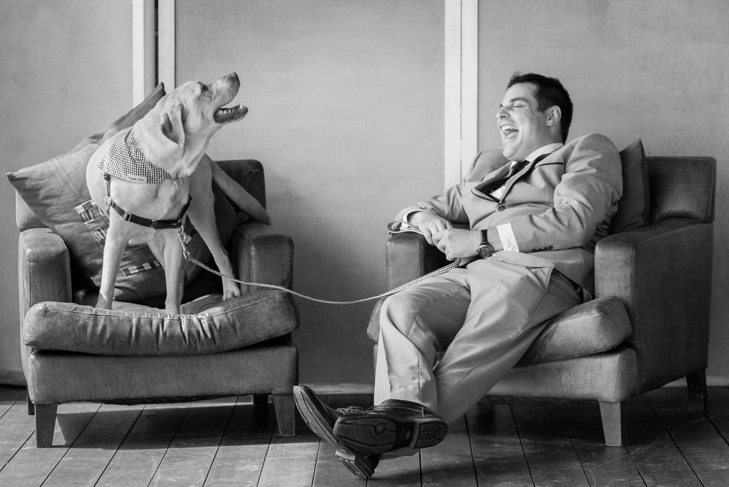 Grayscale image showing a dog and his owner having a laugh together.