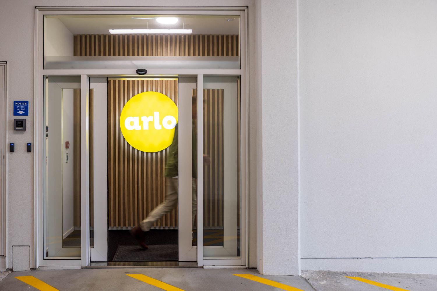 Modern office corridor at Arlo with wooden accents and bright lighting showing multiple doorways.