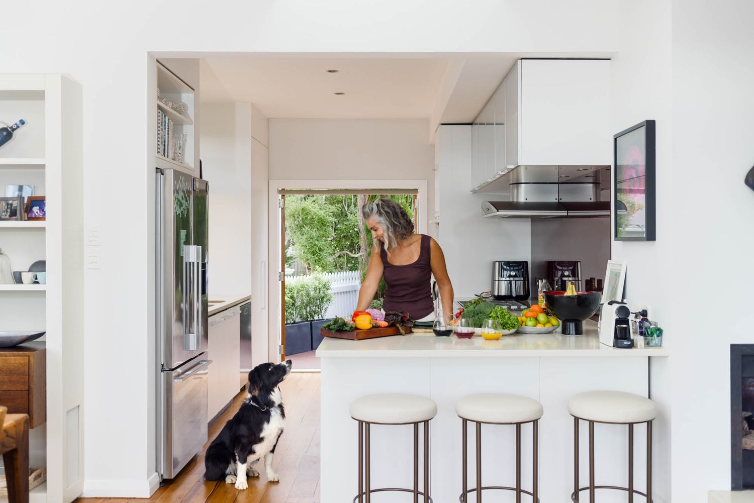 Modern open concept kitchen with white counters and natural lighting.