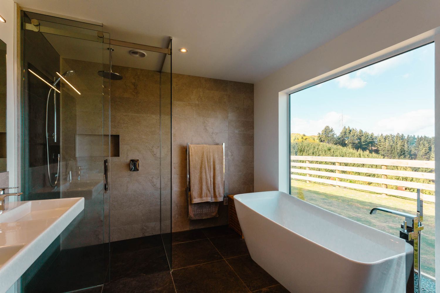 Interior panorama of modern room with large windows offering scenic countryside views.