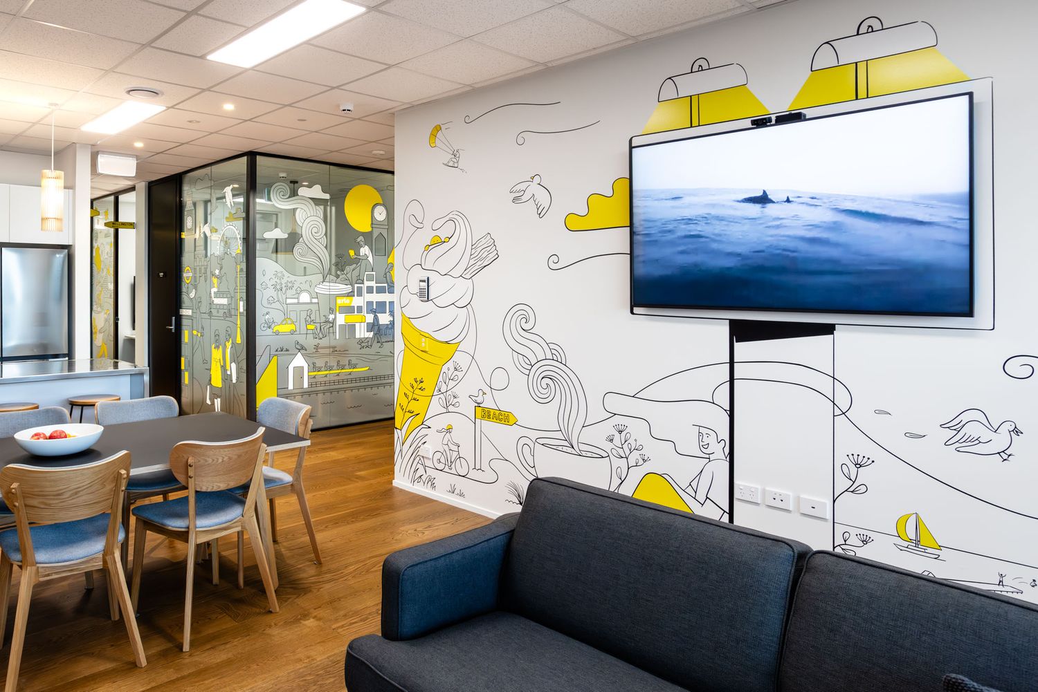 Arlo's modern office space with playful wall illustrations, wooden floors, and collaborative seating areas.