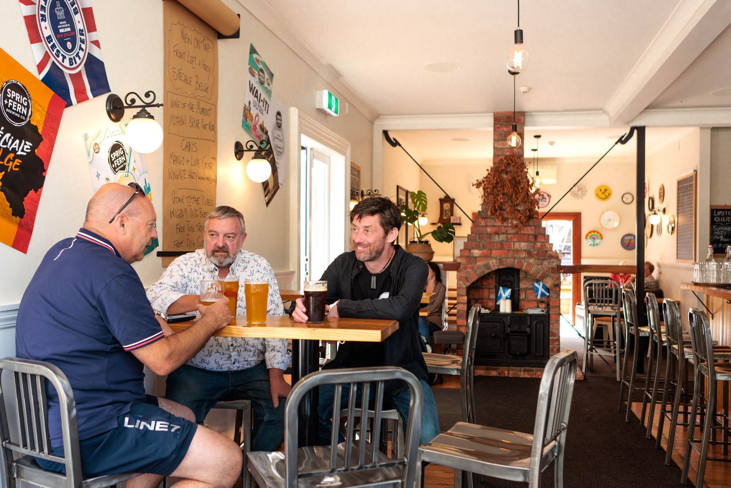 Casual dining area in Sprig and Fern Tavern with metal chairs and exposed brick walls.