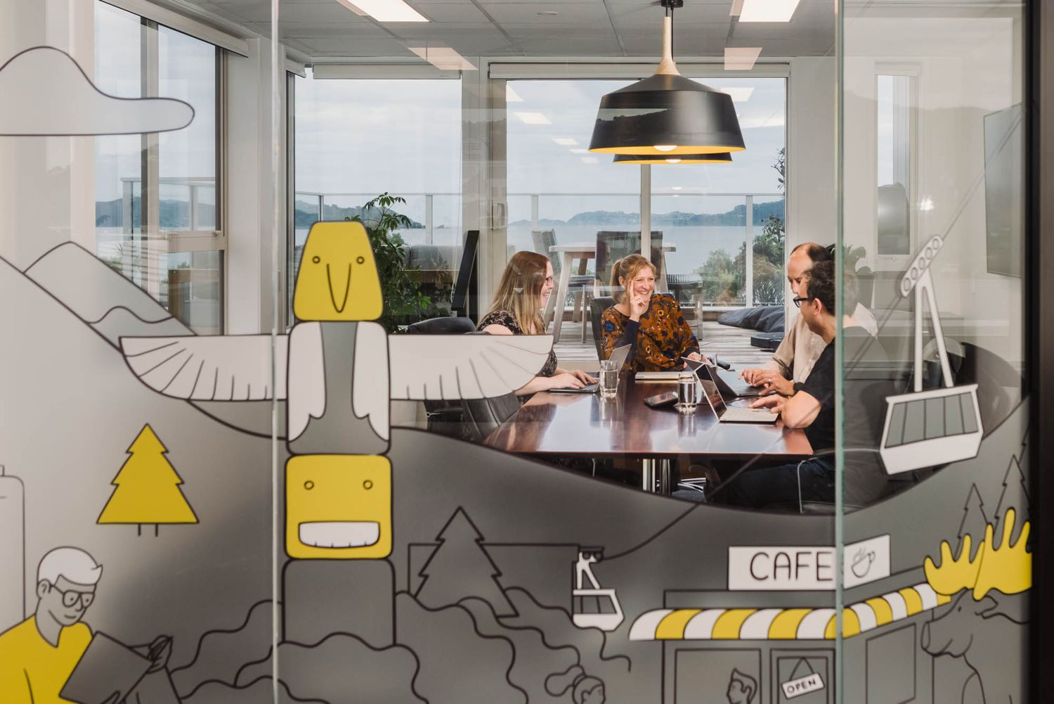 Modern office interior with glass walls featuring decorative geometric designs.
