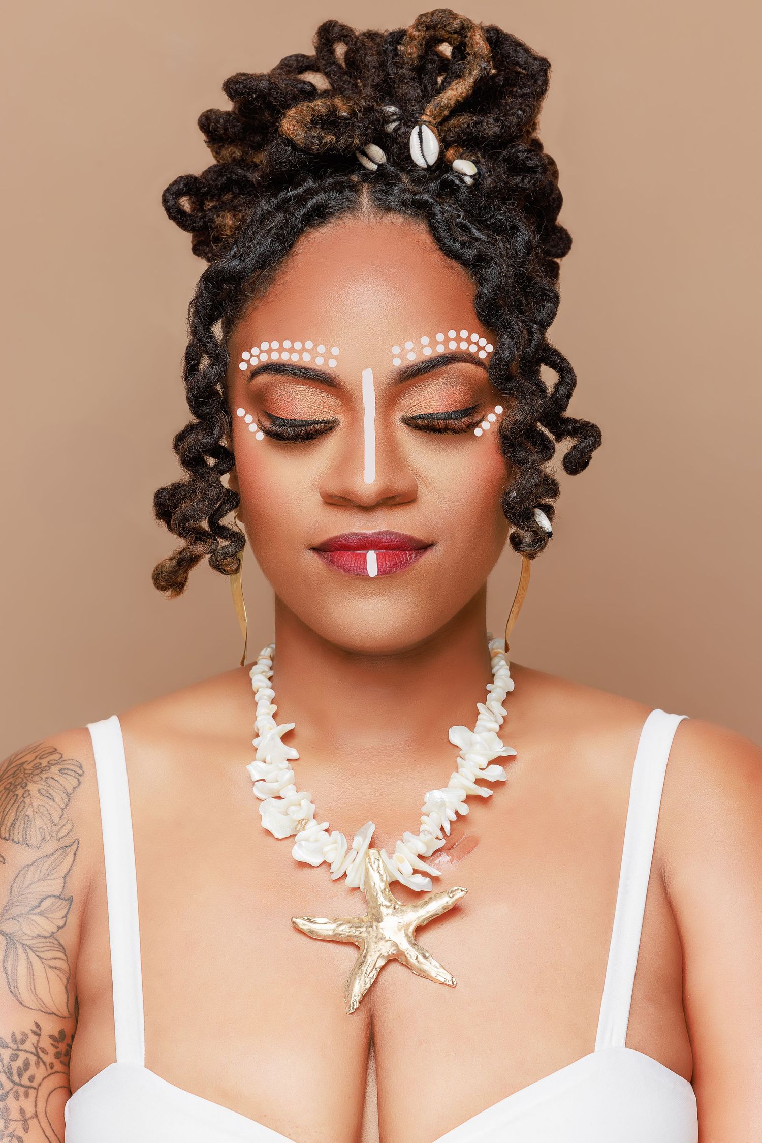 Portrait with tribal face paint, locs hairstyle and seashell necklace against brown background.
