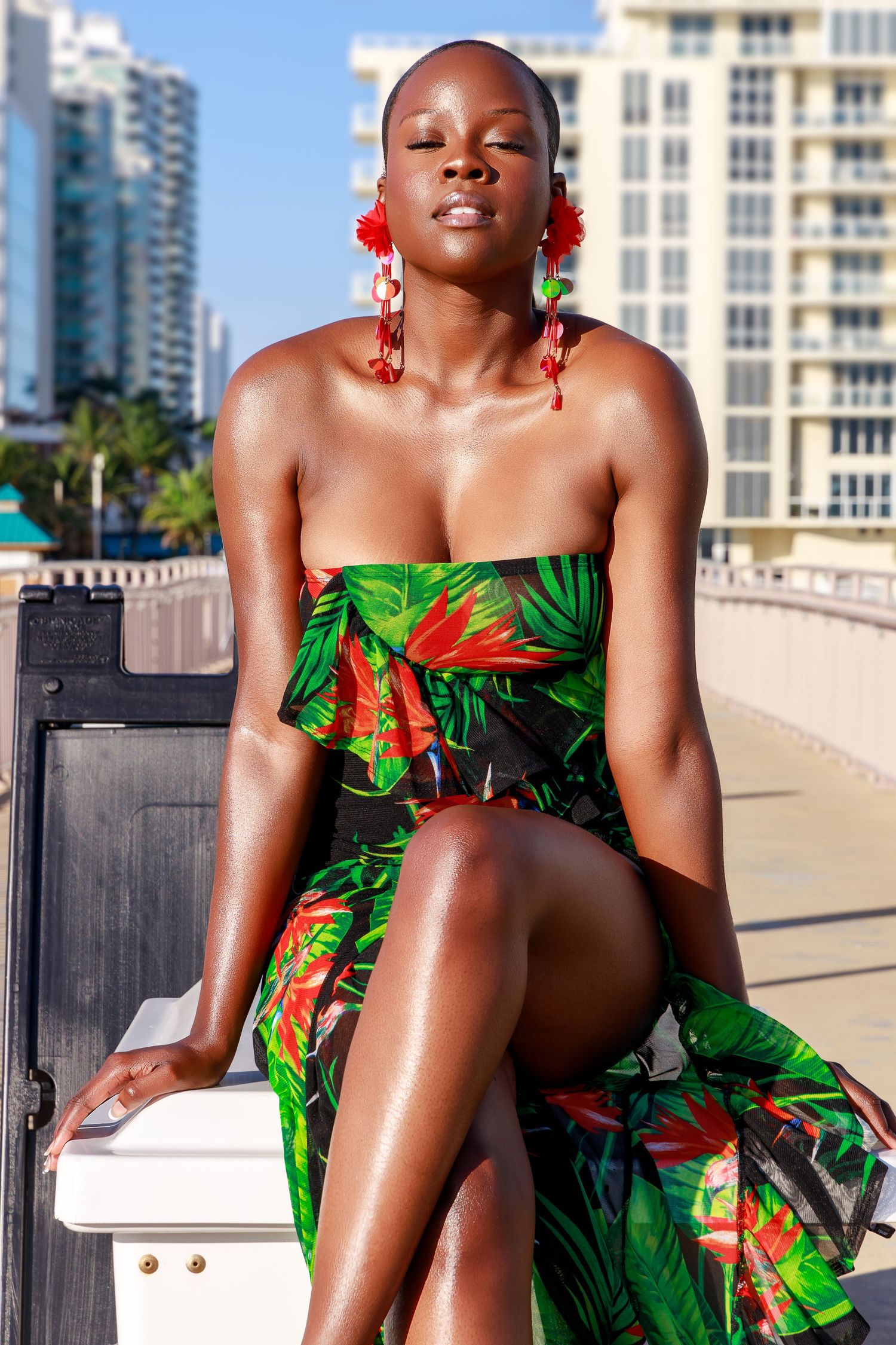 Outdoor fashion photo featuring a tropical print dress against an urban waterfront backdrop.