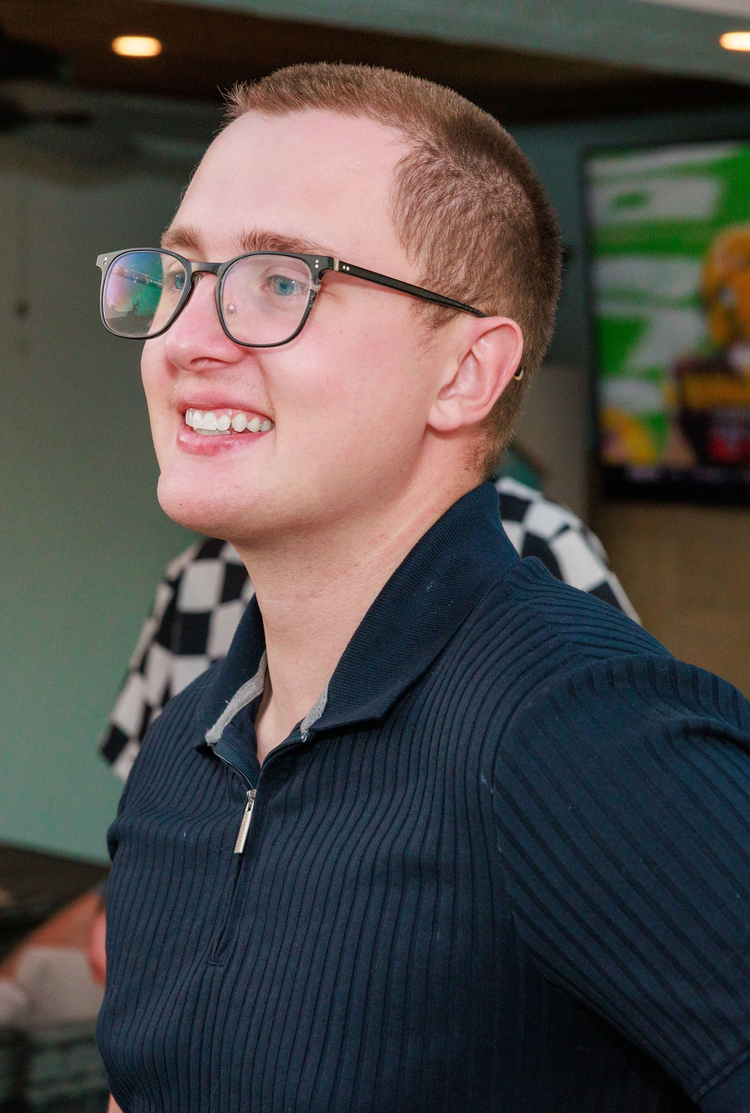 A person wearing glasses and a black sweater is shown smiling in a sequence of candid profile shots.