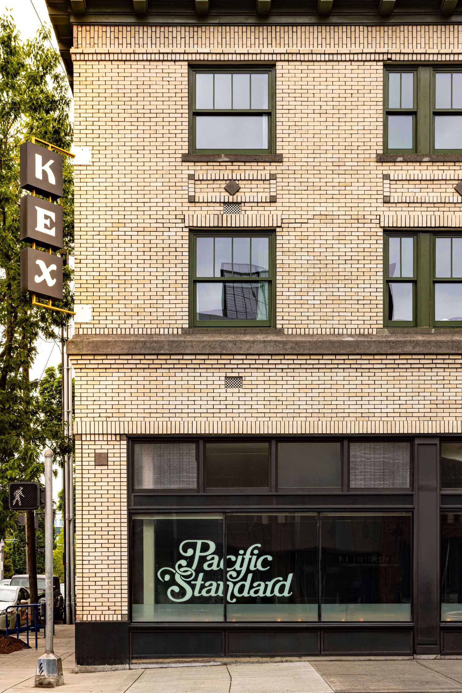 Photo of the exterior of a hotel/restaurant, a beige brick building with two stories above the restaurant level