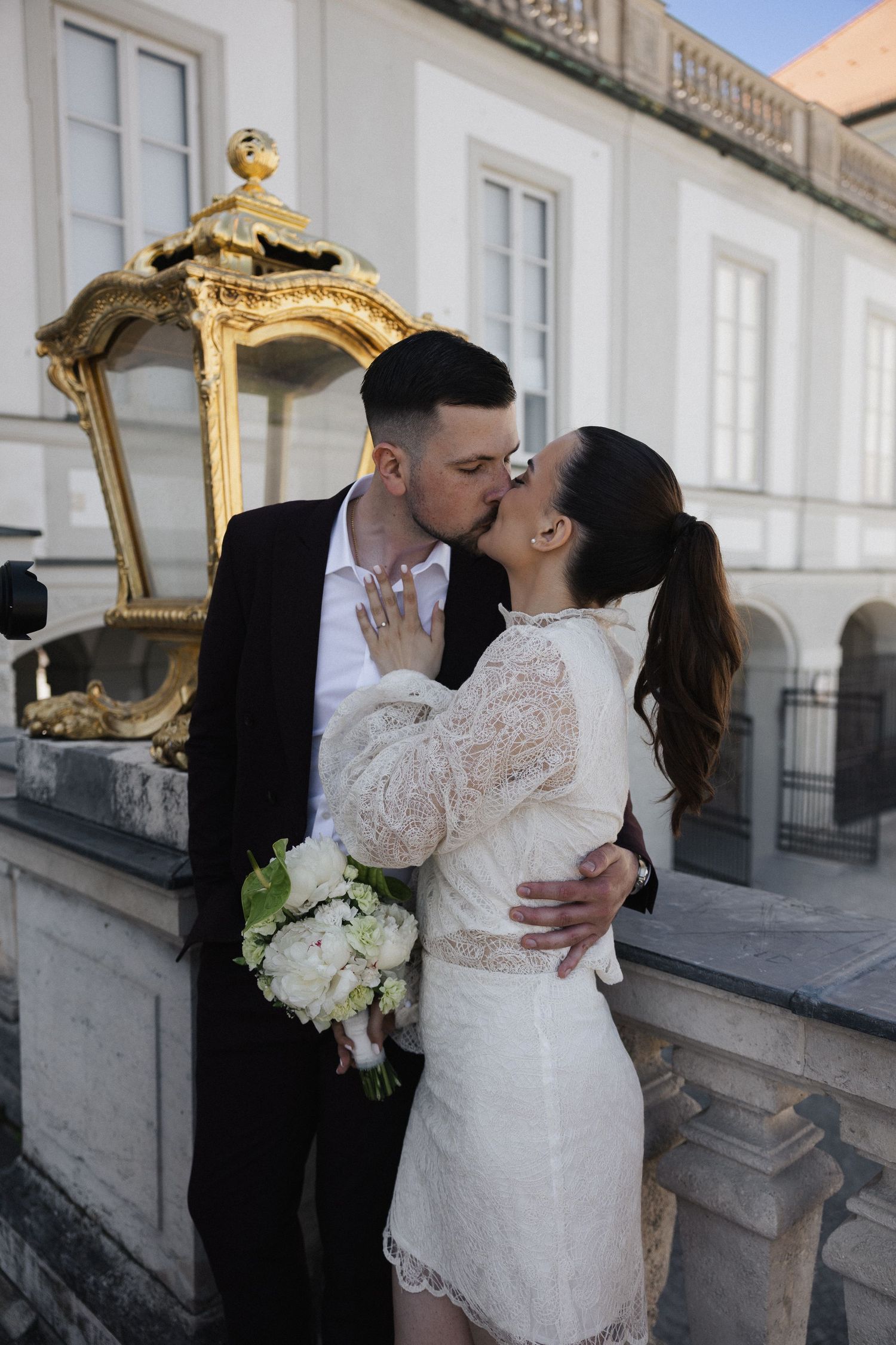 Kuss beim After-Wedding-Fotoshooting: Brautpaar an der Schlossbalustrade in München. Romantische Hochzeitsfotos am Schloss Nymphenburg.