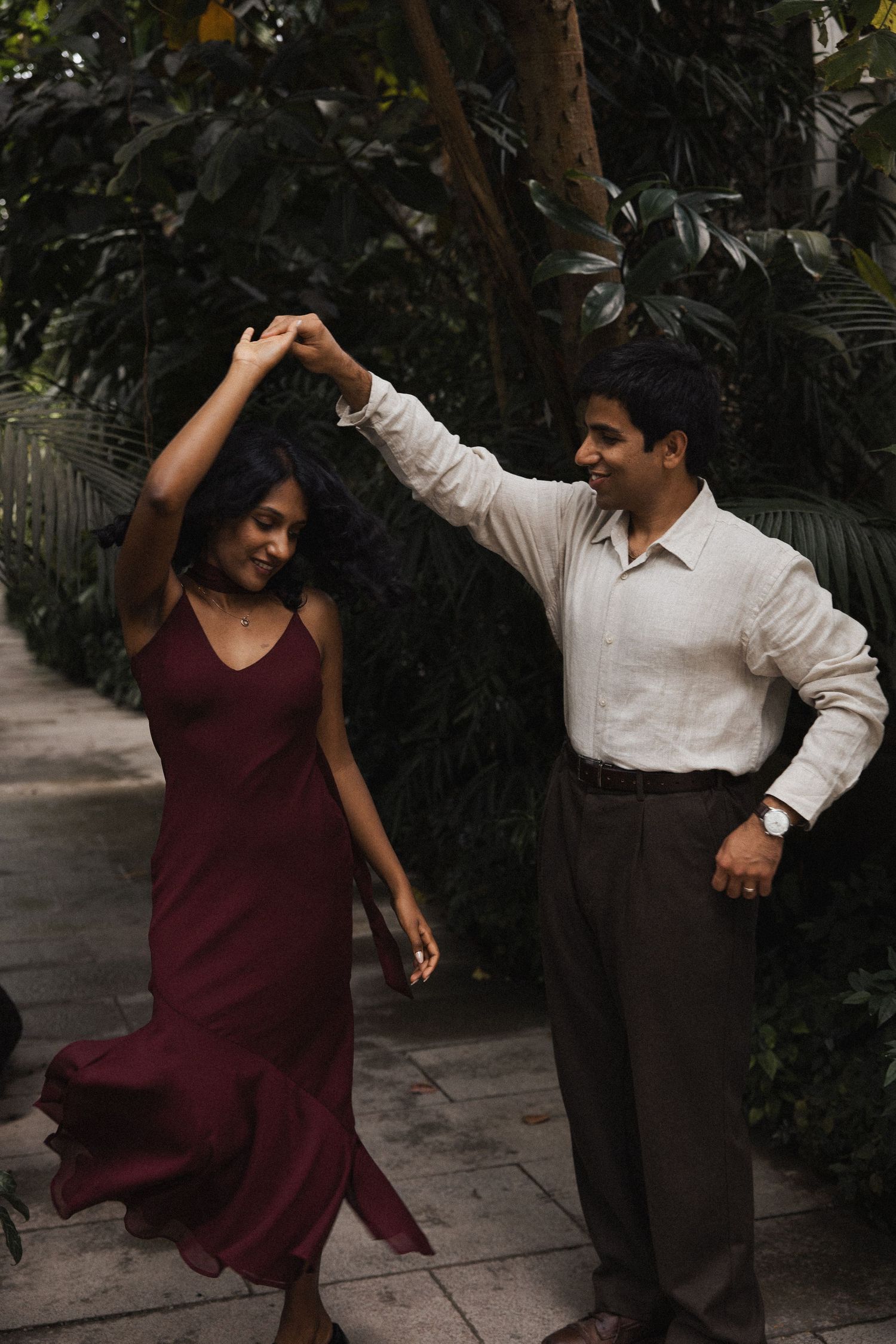 Engagement Shoot im Gewächshaus: Bräutigam dreht Braut im Botanischen Garten München. Dynamisches Paarshooting inmitten von Pflanzen.